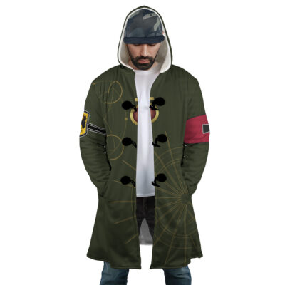 A man wears the Nero Devil May Cry 4 Dream Cloak Coat, featuring a hood, green fabric with abstract yellow and red designs, black toggles, sleeve patches, standing hands in pockets and looking down.