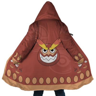 A person wears the Darumaka Pokemon Dream Cloak Coat, featuring a hood, large cartoon face with yellow eyebrows and white zigzag teeth on the back, plus tan ovals and small cartoon figures along the hem and sleeves.