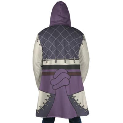 A person wears the Enjin Cosplay Gachiakuta Dream Cloak Coat, featuring a cartoon-style design of two clasped hands, purple and gray colors, and stitch details on the sleeves and lower area. The person faces away from the camera.