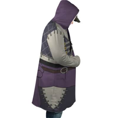 A person stands in profile wearing the Enjin Cosplay Gachiakuta Dream Cloak Coat, featuring a fantasy-inspired hood, purple, grey, and black patches, belt accents, and decorative stitching details.