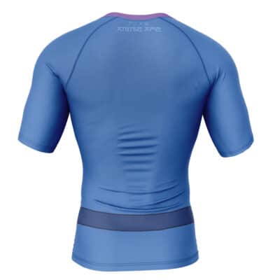The Armor King's Alternate Outfit Tekken 3 Short Sleeve Rash Guard Compression Shirt features a fitted design in blue and purple with subtle seam lines, a printed logo near the neckline, and short sleeves. Seen from the back.