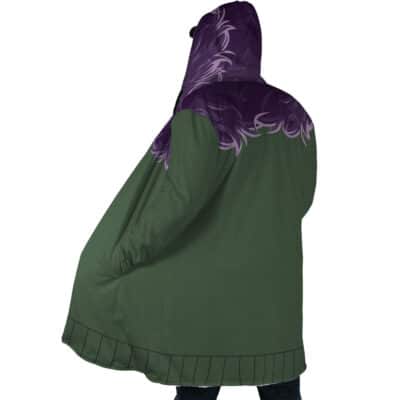 A person wearing the Shinigami Death Seal Shippuden Dream Cloak Coat, green with a purple flame-like design on the hood and shoulders, is seen from the back standing with hands in pockets.