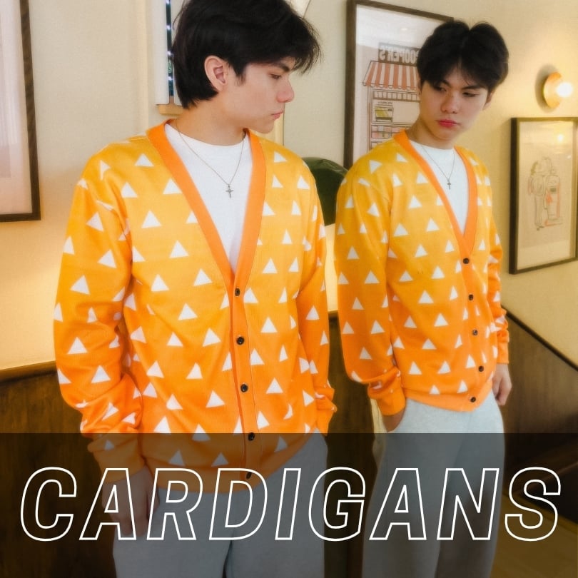 A man wearing a yellow and orange triangle-patterned cardigan over a white t-shirt, standing in front of a mirror, with the text CARDIGANS overlaid at the bottom.